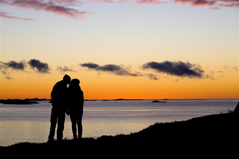 Forelsket par i solnedgang ved havet - Klikk for stort bilde